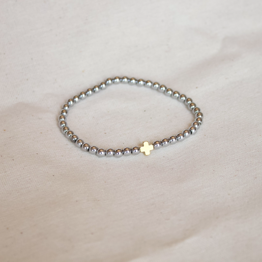 Pulsera plateada con cruz dorada