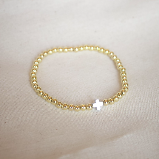 Pulsera dorada con cruz plateada